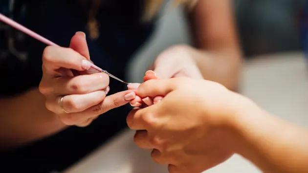 person getting their nails painted at a salon