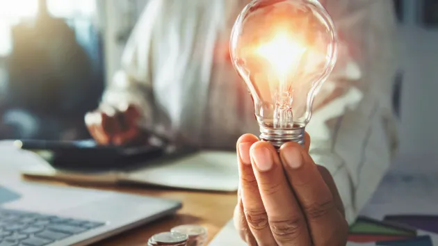 lightbulb and a stack of coins
