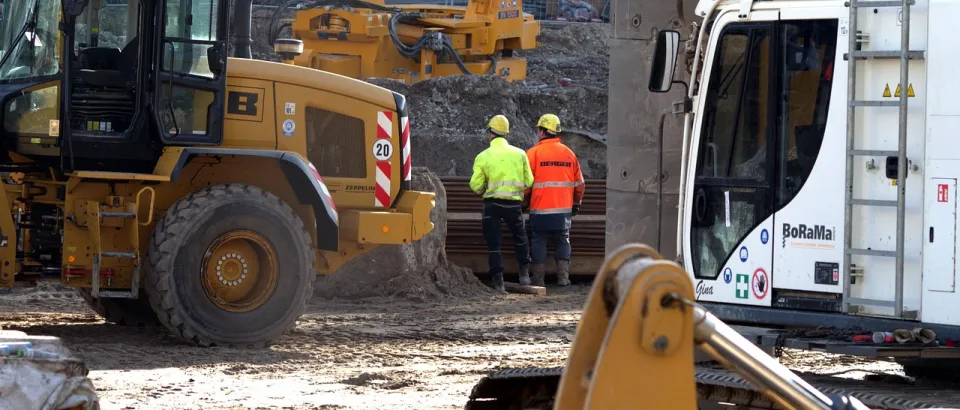 Diggers and two people on a construction site