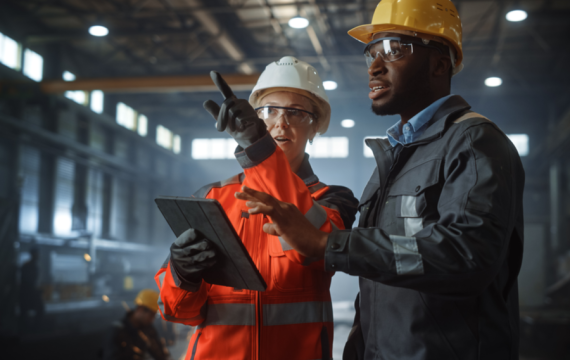 Two Heavy Industry Engineers Stand in Steel Metal Manufacturing Factory