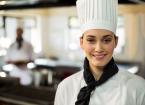 Portrait of smiling chef head standing in commercial kitchen