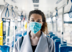 Woman wearing surgical protective mask in a public transportation