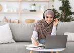 Online Education Muslim Women looking at a laptop wearing headphones