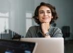 l woman smiling while working with laptop in office