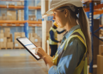 Female Worker Wearing Hard Hat Uses Digital Tablet Computer with Inventory Checking Software