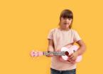 Cheerful disabled girl with Down syndrome looking at camera while playing ukulele,