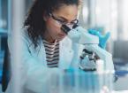 Female Scientist Looking Under Microscope Does Analysis of Test Sample.