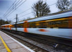 Commuter train departing a UK station and gathering speed