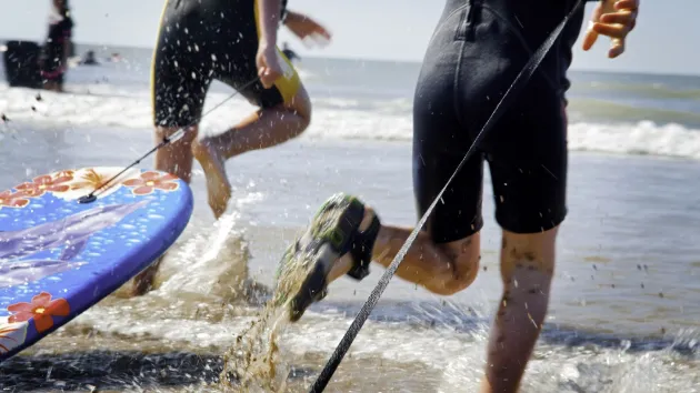 Children body boarding Rest Bay beach Porthcawl Vale Of Glamorgan South Surfing Activities and Sports