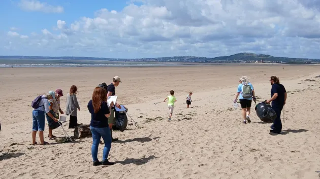Beach clean - people collecting rubbish from a beach 