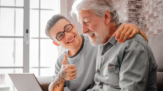 Older person and younger person looking at a digital device 