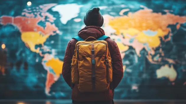 Person looking at a map of the world, planing to travel 