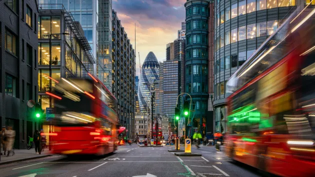 Sunset at the City of London, England, with street traffic light trails and illuminated skyscrapers