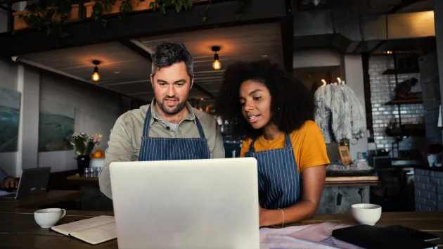 Small Business Owners looking at a digital device