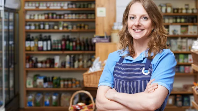 Deli owner looking at jars of honey 