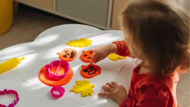 Child at nursery class painting a pumpkin