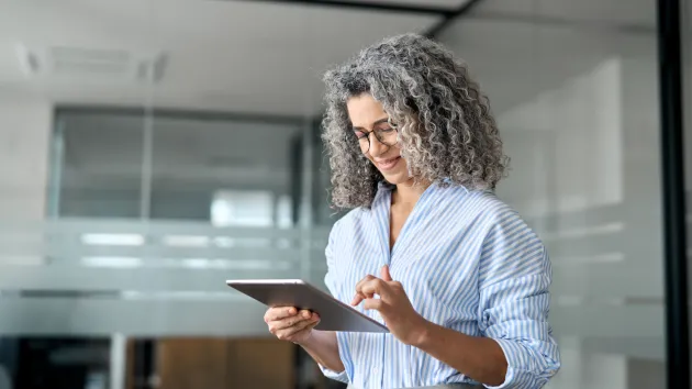Mature Business owner looking at a digital device 