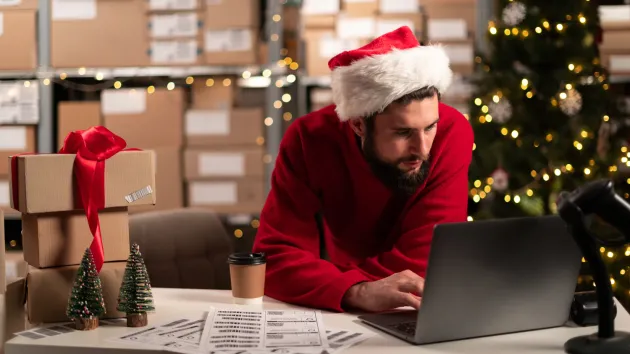 small business owner wearing a santa hat working in an office