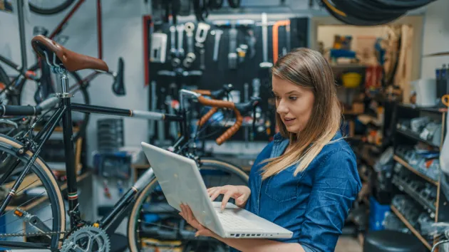 Young female mechanic with laptop. 