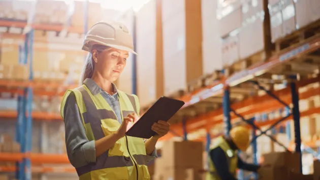 Warehouse worker looing at a digital tablet 