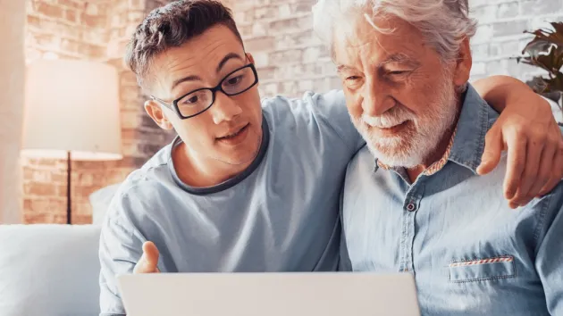 Younger generation caring about older relatives teaching using computer