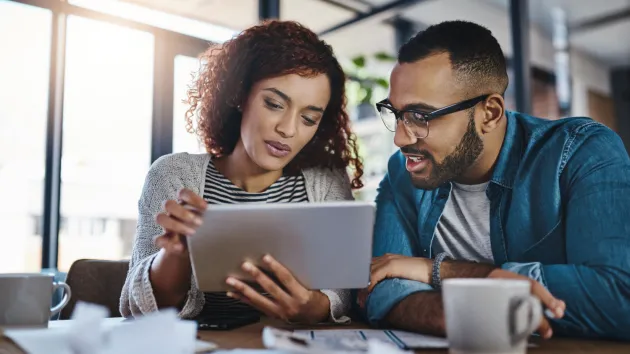 Small business owners looking at a digital device 