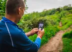 Llanynynech Hillside, Offa's Dyke Path, Powys. - person using a mobile phone whilst walking 