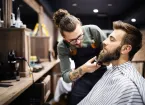 Barber trimming a client's beard 
