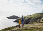 family walking near a lighthouse 