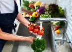 Kitchen staff washing vegetables for food prep