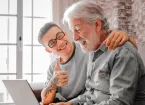 Older person and younger person looking at a digital device 