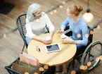Wheelchair user working in an office talking to a colleague