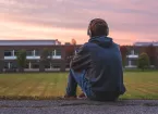 teenager sitting in field 