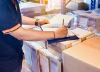 person filling out paperwork for sending parcels 