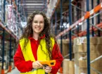 Warehouse worker wearing a red jumper and yellow vest 