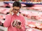 Person reading a label on packaged meat 