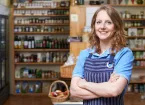 Deli owner looking at jars of honey 