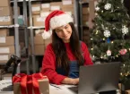 Warehouse worker wearing a Santa hat and packing parcels