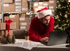 small business owner wearing a santa hat working in an office