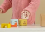 child stacking wooden building blocks 