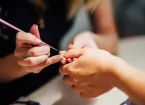 person getting their nails painted at a salon