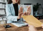 Person refusing to taken a bribe, money in an envelop 