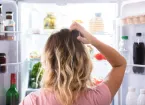 person looking puzzled at fridge contents 