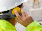 Construction worker wearing protective hard hat and ear defenders