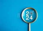 2024 and magnifying glass to depict business goals for 2024