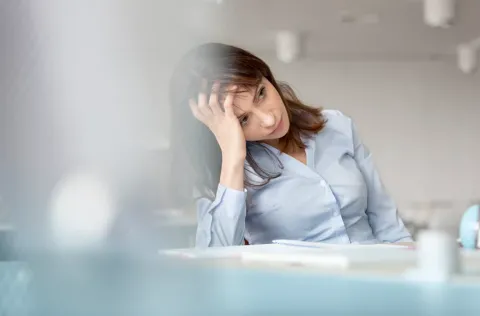 woman with blue shirt looking stressed