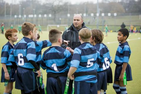 Young children getting advice from Rugby coach