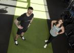 natalie and lewis stood in their gym studio on a green carpet