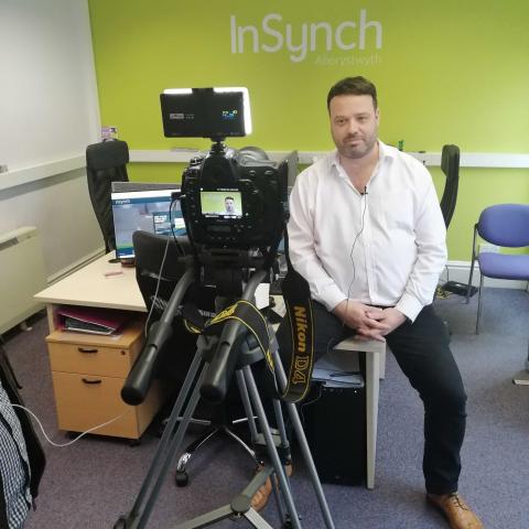 InSynch CEO, Eddy Webb in front of a camera.