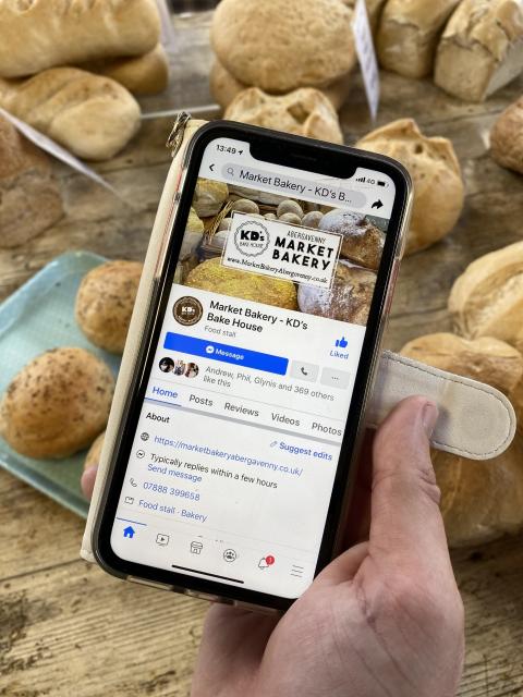 A smartphone showing KD's Bakehouse's Facebook page.